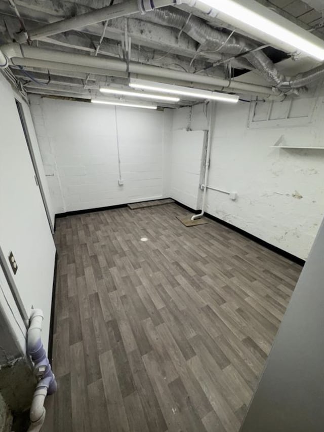 unfinished below grade area with wood finished floors and baseboards