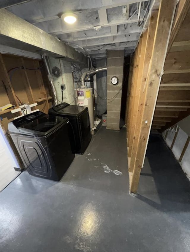 unfinished below grade area featuring washing machine and clothes dryer and water heater