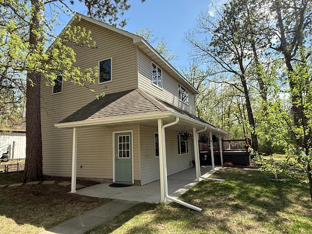 5502 Mallard Ln NE, Bemidji, MN 56601 - back of house with roof with shingles, a lawn, and a wooden deck