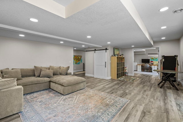 19883 Evensong Ct, Farmington, MN 55024 - living room featuring a barn door, wood finished floors, a desk, recessed lighting, and baseboards