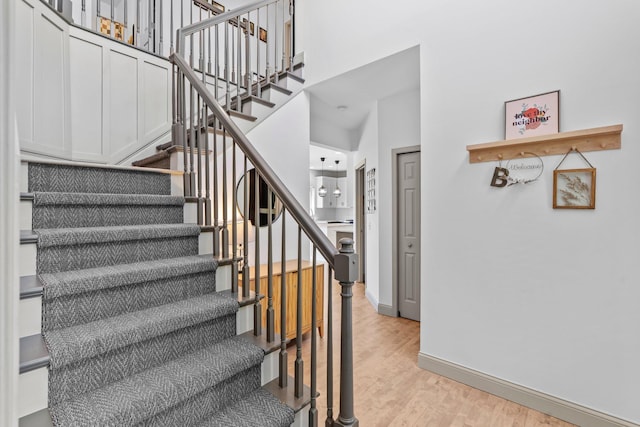 19883 Evensong Ct, Farmington, MN 55024 - staircase with wood finished floors, baseboards, and a towering ceiling