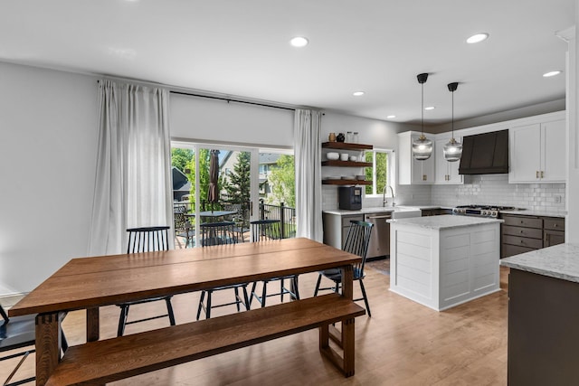 19883 Evensong Ct, Farmington, MN 55024 - kitchen with custom range hood, stainless steel appliances, a center island, tasteful backsplash, and hanging light fixtures