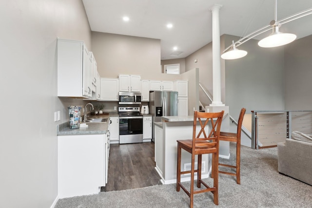 3394 Spring Glen Cir NW, Prior Lake, MN 55372 - kitchen featuring appliances with stainless steel finishes, a sink, white cabinetry, a breakfast bar, and a high ceiling