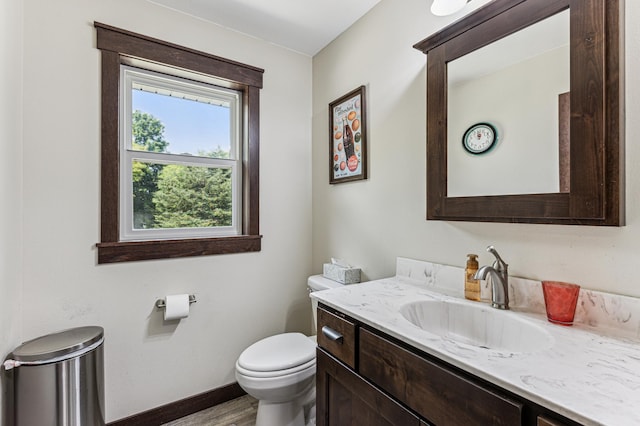 10798 Quiner Ave NW, Southside Twp, MN 55382 - half bathroom with toilet, vanity, wood finished floors, and baseboards
