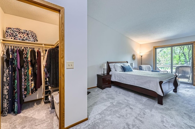 bedroom with carpet floors, a textured ceiling, access to exterior, baseboards, and lofted ceiling