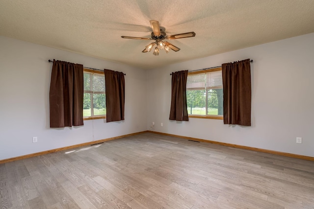 24058 610th Ave, Madison Lake, MN 56063 - spare room featuring healthy amount of natural light, ceiling fan, light wood-style flooring, a textured ceiling, and baseboards