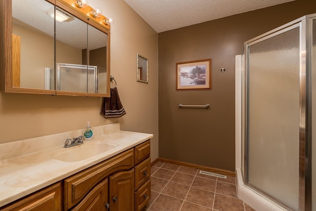 24058 610th Ave, Madison Lake, MN 56063 - full bathroom featuring a shower stall, vanity, a textured ceiling, baseboards, and tile patterned flooring