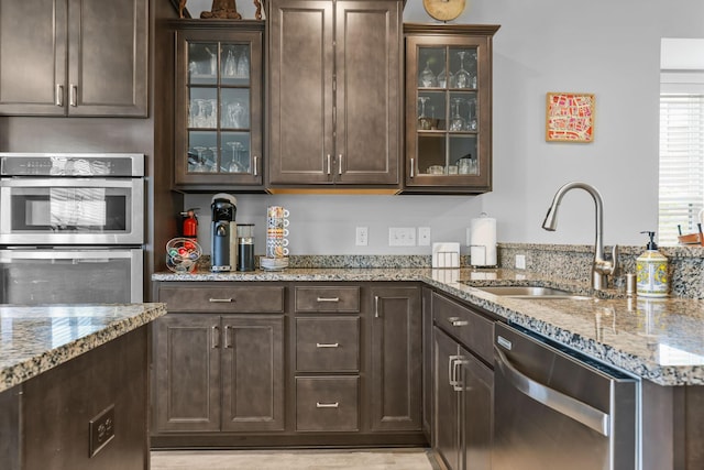 4014 River Valley Way, Eagan, MN 55122 - kitchen featuring stainless steel appliances, a sink, dark brown cabinetry, and light stone countertops