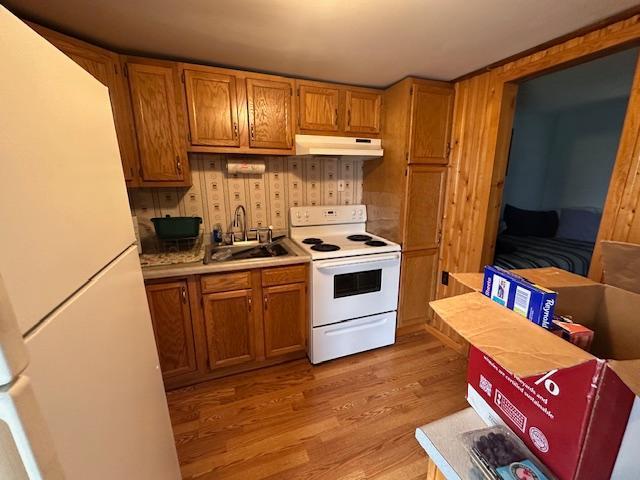 2377 Finn Bay Rd, Babbitt, MN 55706 - kitchen with white appliances, a sink, under cabinet range hood, brown cabinets, and light countertops