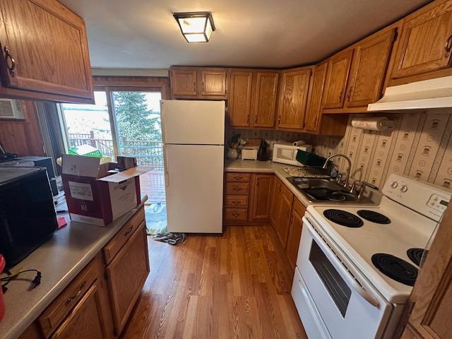 2377 Finn Bay Rd, Babbitt, MN 55706 - kitchen featuring white appliances, brown cabinets, a sink, and under cabinet range hood