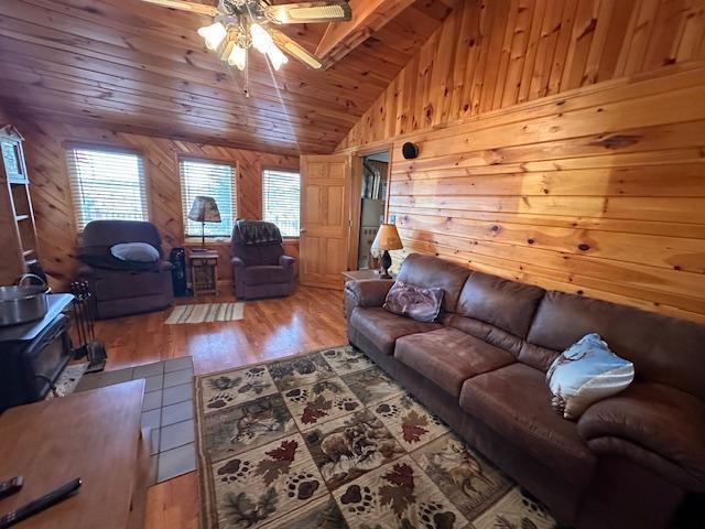 2377 Finn Bay Rd, Babbitt, MN 55706 - living area featuring lofted ceiling, wooden walls, ceiling fan, plenty of natural light, and a wood stove