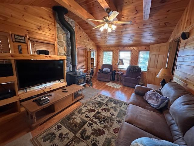 2377 Finn Bay Rd, Babbitt, MN 55706 - living area featuring a wood stove, wood ceiling, wooden walls, wood finished floors, and a ceiling fan