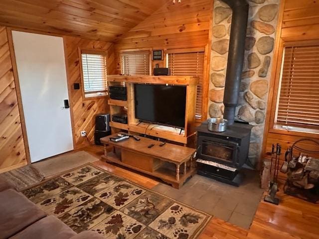 2377 Finn Bay Rd, Babbitt, MN 55706 - living room featuring a wood stove, lofted ceiling, wood finished floors, wood ceiling, and wooden walls