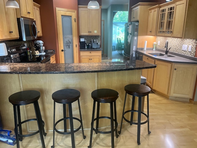 1808 4th St NE, Willmar, MN 56201 - kitchen with appliances with stainless steel finishes, a sink, backsplash, a peninsula, and glass insert cabinets