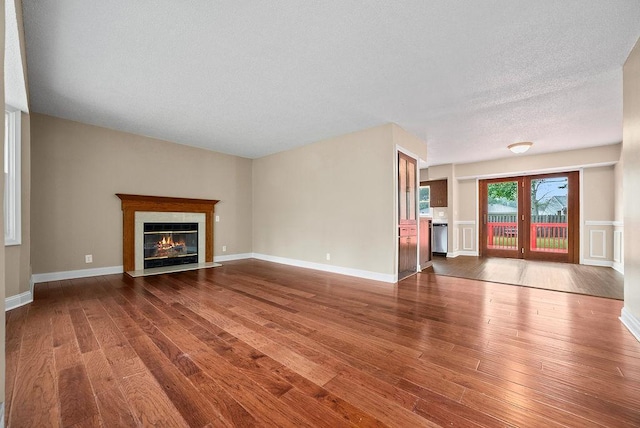 3013 64th Ave N, Brooklyn Center, MN 55429 - unfurnished living room featuring a fireplace with flush hearth, wood finished floors, and a textured ceiling