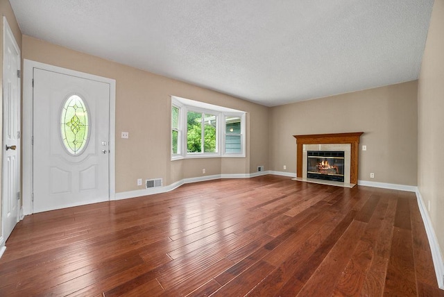 3013 64th Ave N, Brooklyn Center, MN 55429 - entryway with hardwood / wood-style floors, a textured ceiling, a fireplace with flush hearth, and baseboards