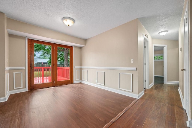 3013 64th Ave N, Brooklyn Center, MN 55429 - spare room featuring hardwood / wood-style floors, a textured ceiling, and baseboards