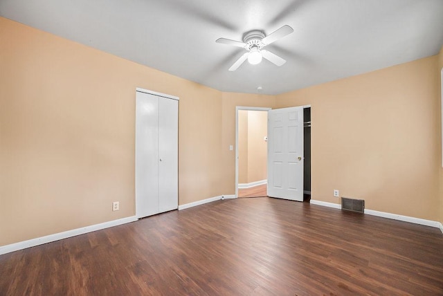 3013 64th Ave N, Brooklyn Center, MN 55429 - unfurnished bedroom featuring baseboards, wood finished floors, ceiling fan, and multiple closets