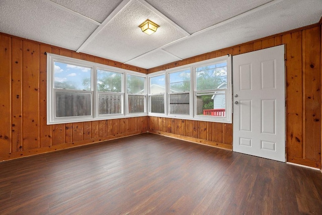 3013 64th Ave N, Brooklyn Center, MN 55429 - unfurnished sunroom with wood finished floors, wood walls, baseboards, and a textured ceiling