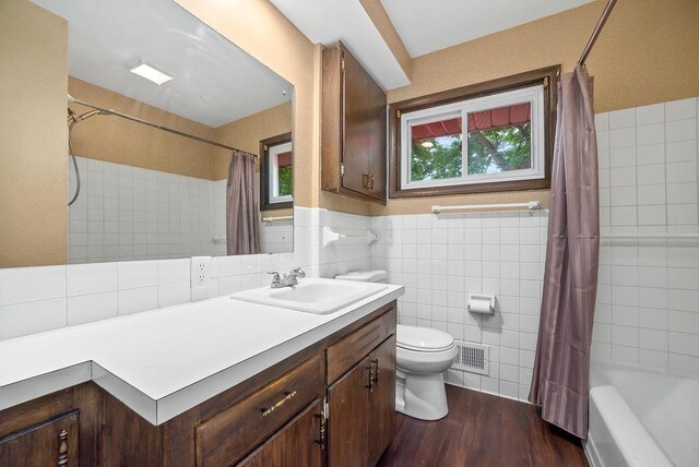3013 64th Ave N, Brooklyn Center, MN 55429 - bathroom featuring tile walls, toilet, vanity, shower / bath combination with curtain, and wood finished floors
