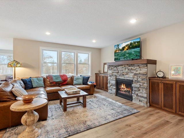 16524 Piper Ln, Brainerd, MN 56401 - living room with light wood finished floors, a stone fireplace, a textured ceiling, and recessed lighting
