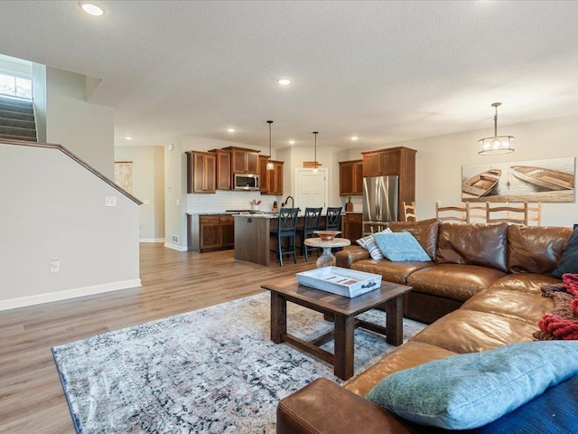 16524 Piper Ln, Brainerd, MN 56401 - living area with light wood-type flooring, stairs, recessed lighting, baseboards, and a chandelier