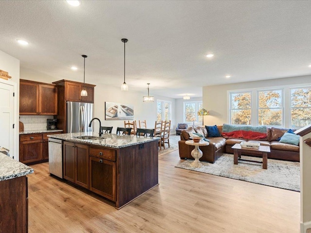 16524 Piper Ln, Brainerd, MN 56401 - kitchen with stainless steel appliances, a sink, light wood-style floors, open floor plan, and backsplash