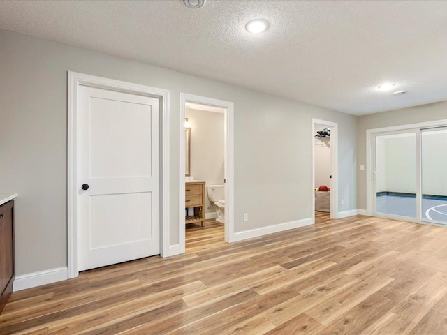 16524 Piper Ln, Brainerd, MN 56401 - unfurnished bedroom with light wood-style floors, baseboards, a textured ceiling, ensuite bath, and recessed lighting
