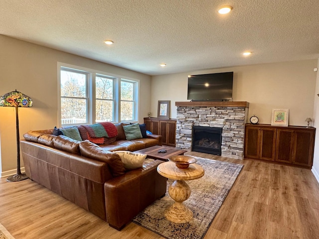 16524 Piper Ln, Brainerd, MN 56401 - living room featuring light wood-type flooring, a textured ceiling, a fireplace, baseboards, and recessed lighting