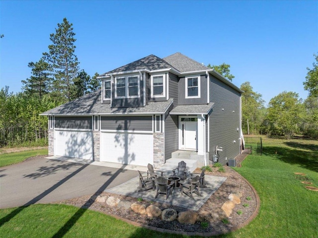 16524 Piper Ln, Brainerd, MN 56401 - view of front of home with asphalt driveway, a front lawn, a shingled roof, and stone siding