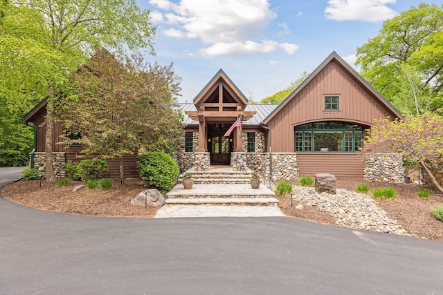 2442 Meeting St, Minnetonka, MN 55391 - view of front of house with a standing seam roof, stone siding, and metal roof