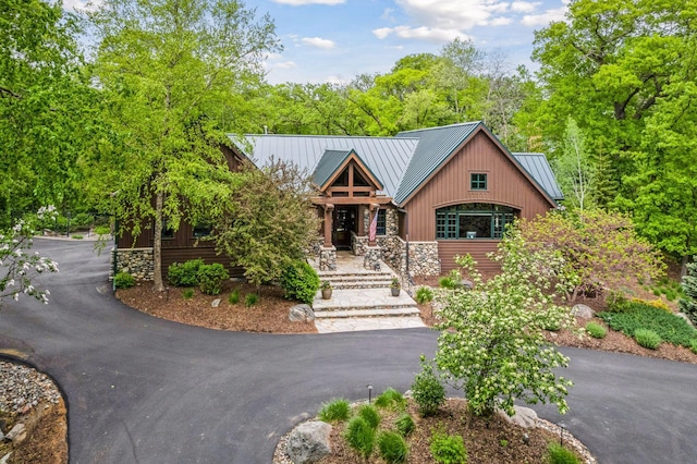 2442 Meeting St, Minnetonka, MN 55391 - view of front of property with a standing seam roof, driveway, metal roof, a porch, and stone siding
