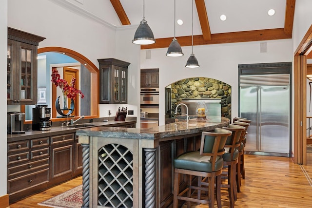 2442 Meeting St, Minnetonka, MN 55391 - bar area with stainless steel appliances, beam ceiling, light wood finished floors, decorative light fixtures, and a sink