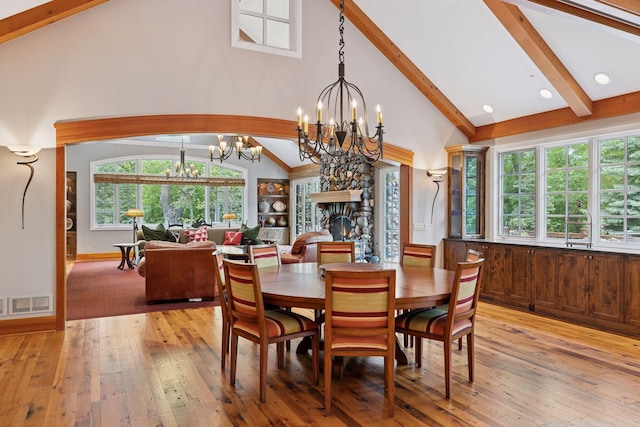 2442 Meeting St, Minnetonka, MN 55391 - dining room with a chandelier, beamed ceiling, high vaulted ceiling, light wood-style floors, and a stone fireplace