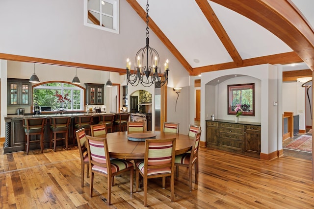2442 Meeting St, Minnetonka, MN 55391 - dining space featuring high vaulted ceiling, light wood-style flooring, beam ceiling, arched walkways, and a chandelier