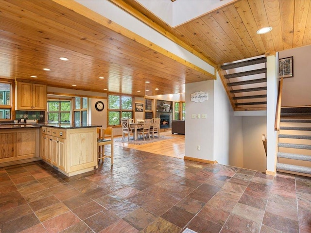 27620 Island View Dr, Park Rapids, MN 56470 - kitchen featuring dark countertops, stone tile flooring, recessed lighting, a breakfast bar area, and wooden ceiling