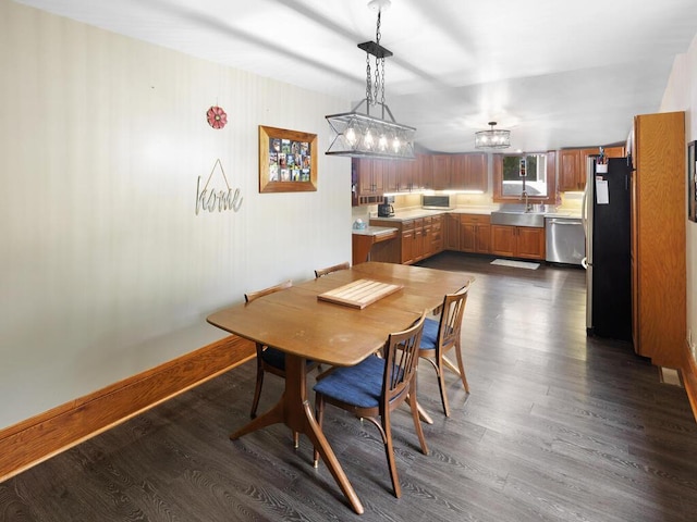 601 Kingsway Dr, Le Sueur, MN 56058 - dining area with dark wood finished floors, a chandelier, and baseboards