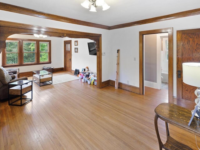 601 Kingsway Dr, Le Sueur, MN 56058 - living room featuring light wood-style floors, baseboards, crown molding, arched walkways, and a chandelier