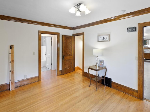 601 Kingsway Dr, Le Sueur, MN 56058 - empty room featuring crown molding, light wood finished floors, and baseboards