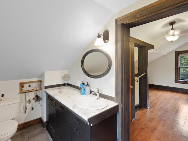 601 Kingsway Dr, Le Sueur, MN 56058 - bathroom with vaulted ceiling, toilet, vanity, ceiling fan, and baseboards