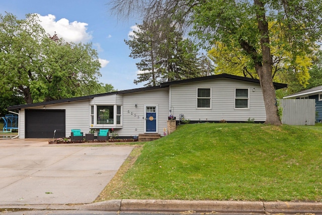 view of front of home featuring entry steps, a garage, driveway, and a front lawn