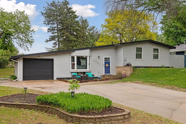 view of front of house featuring driveway, an attached garage, and a front yard