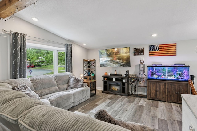 living room with lofted ceiling, recessed lighting, wood finished floors, and baseboards