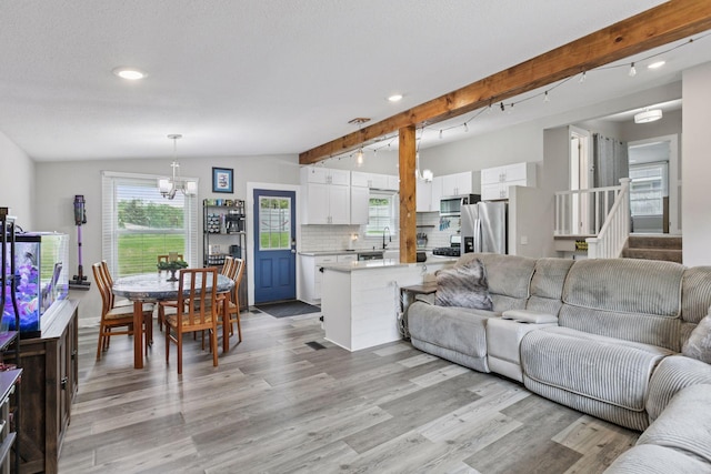 living room with light wood-style flooring, plenty of natural light, a chandelier, recessed lighting, and stairway