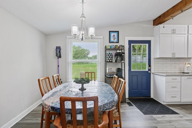 dining room with a chandelier, dark wood-style floors, and baseboards