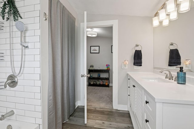 full bathroom with wood finished floors, vanity, and baseboards