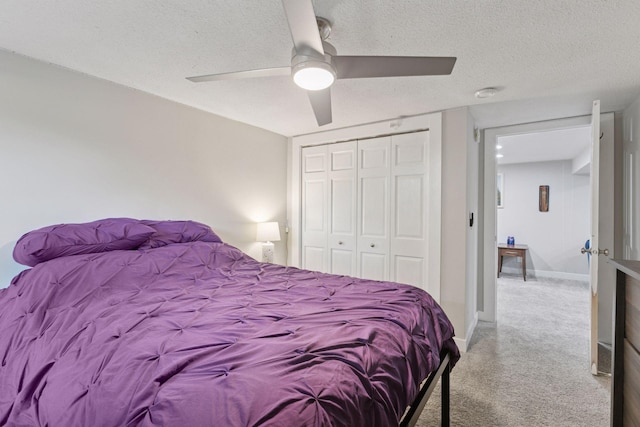 carpeted bedroom featuring a closet, a textured ceiling, a ceiling fan, and baseboards