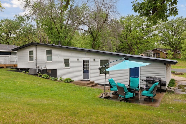 back of house featuring a lawn and central AC