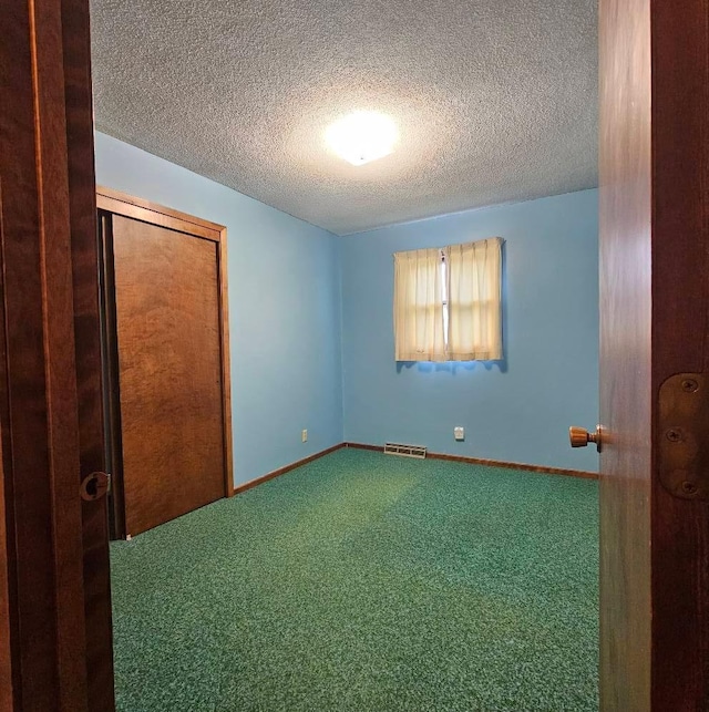 701 10th St NE, Austin, MN 55912 - unfurnished bedroom featuring a textured ceiling, carpet flooring, baseboards, and a closet