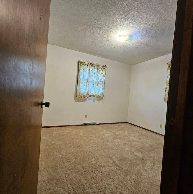 701 10th St NE, Austin, MN 55912 - carpeted empty room with a textured ceiling and baseboards